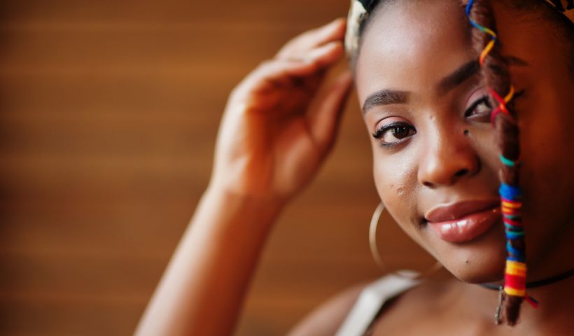 Trancista sorrindo com tranças coloridas